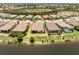 Aerial view of a home on the lake surrounded by lush landscaping and other homes in the neighborhood at 26825 Weiskopf Dr, Englewood, FL 34223