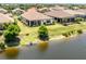 Aerial view of the backyard featuring a lake view and green landscaping, screened-in lanai at 26825 Weiskopf Dr, Englewood, FL 34223