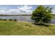 Lakeside backyard featuring lush green grass and a tranquil waterfront view at 26825 Weiskopf Dr, Englewood, FL 34223