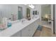 Spacious bathroom with double sink vanity and tile floor, leading to the Primary bedroom at 26825 Weiskopf Dr, Englewood, FL 34223