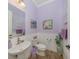 Charming powder room features a stylish pedestal sink, toilet and beautiful decor at 26825 Weiskopf Dr, Englewood, FL 34223