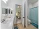 Bright bathroom with a tiled floor featuring a toilet with a blue shower curtain at 26825 Weiskopf Dr, Englewood, FL 34223