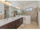 Elegant bathroom with a double vanity, sleek fixtures, and a glass-enclosed shower at 26825 Weiskopf Dr, Englewood, FL 34223