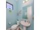 Light blue bathroom with a pedestal sink, toilet and nautical decor at 26825 Weiskopf Dr, Englewood, FL 34223