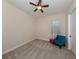 This bedroom features neutral carpet, a ceiling fan, and a cheerful sitting area at 26825 Weiskopf Dr, Englewood, FL 34223