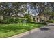 Exterior of the community clubhouse with lush landscaping, mature trees and a manicured lawn at 26825 Weiskopf Dr, Englewood, FL 34223
