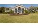 Well-manicured lawn leads to a lush landscape surrounding the entrance to the community clubhouse at 26825 Weiskopf Dr, Englewood, FL 34223
