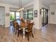 Formal dining area with a wooden table, stylish chairs, and scenic views from the large windows at 26825 Weiskopf Dr, Englewood, FL 34223