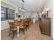 Bright dining room flows into the kitchen, featuring wood floors and an elegant chandelier above dining table at 26825 Weiskopf Dr, Englewood, FL 34223