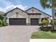 Attractive home with a brick driveway, a two-car garage, and beautifully landscaped grounds at 26825 Weiskopf Dr, Englewood, FL 34223