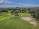 Aerial view of the golf course with meticulously maintained fairways, mature trees, and well placed sand traps at 26825 Weiskopf Dr, Englewood, FL 34223