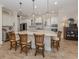 Elegant kitchen with a large center island, pendant lighting, and wooden counter chairs at 26825 Weiskopf Dr, Englewood, FL 34223