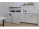 Well-equipped laundry room with washer, dryer, sink, and plenty of storage space at 26825 Weiskopf Dr, Englewood, FL 34223