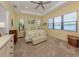 Serene main bedroom with large windows and a comfortable seating area, offering picturesque lake views at 26825 Weiskopf Dr, Englewood, FL 34223