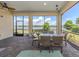 Screened lanai with comfortable seating, offering serene views of the lake and surrounding landscape at 26825 Weiskopf Dr, Englewood, FL 34223