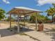 Shaded pavilion with picnic tables invites relaxation and gathering in a tranquil park setting at 26825 Weiskopf Dr, Englewood, FL 34223