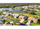 An aerial perspective displays the home's neighborhood near a tranquil lake with lush lawns and mature trees at 3203 Meadow Run Dr, Venice, FL 34293