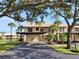 Inviting condo exterior with mature trees, covered parking, and well-maintained landscaping at 345 Three Lakes Ln # L, Venice, FL 34285