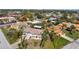 Two-story home with roof deck surrounded by lush landscaping and mature palm trees in a neighborhood setting at 397 Flamingo Dr, Venice, FL 34285