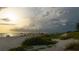 Scenic beach landscape with vegetation and a dramatic sky at sunset, creating a peaceful atmosphere at 397 Flamingo Dr, Venice, FL 34285