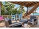 Back deck with seating area surrounded by tropical trees at 397 Flamingo Dr, Venice, FL 34285