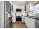 Well-lit kitchen with stainless steel appliances, white cabinets, and a unique brick floor at 397 Flamingo Dr, Venice, FL 34285
