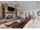 Living room with a stone fireplace, ceiling fan, and sliding glass doors to the backyard deck at 397 Flamingo Dr, Venice, FL 34285