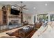 Living room with a stone fireplace, ceiling fan, and sliding glass doors to the backyard deck at 397 Flamingo Dr, Venice, FL 34285