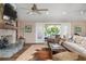 Cozy living room featuring a stone fireplace, ceiling fans and French doors to an outdoor deck at 397 Flamingo Dr, Venice, FL 34285