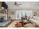 Cozy living room featuring a stone fireplace, ceiling fans and French doors to an outdoor deck at 397 Flamingo Dr, Venice, FL 34285
