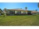 A backyard with a green lawn, landscaping, and a home with a patio and tile roof at 4121 Bella Pasque, Venice, FL 34293