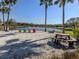Picturesque beach with picnic tables and lounge chairs facing a tranquil lake at 4238 Mackay Falls Ter, Sarasota, FL 34243