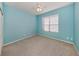 Bedroom with light blue walls, carpeted floors, and a window providing natural light at 4238 Mackay Falls Ter, Sarasota, FL 34243