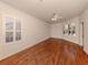 Spacious bedroom featuring hardwood floors, a ceiling fan, and natural light from two windows with shutters at 4238 Mackay Falls Ter, Sarasota, FL 34243