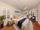 Bedroom featuring a bed with a blue throw, matching chair and side tables, and shuttered windows at 4238 Mackay Falls Ter, Sarasota, FL 34243