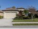 Charming single-story home featuring a well-manicured lawn and beautiful tropical landscaping at 4238 Mackay Falls Ter, Sarasota, FL 34243