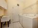 Well-lit laundry room featuring a utility sink, washer, dryer, and storage shelves at 4238 Mackay Falls Ter, Sarasota, FL 34243