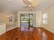 Bright living room features wood floors, ceiling fan, sliding glass doors to screened patio, and white shutters at 4238 Mackay Falls Ter, Sarasota, FL 34243