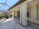 Covered patio with tile flooring, ceiling fans, and access to both the house and screened-in pool area at 4238 Mackay Falls Ter, Sarasota, FL 34243