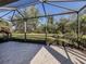 A view of the screened patio with pavers leading to the green, landscaped backyard at 4238 Mackay Falls Ter, Sarasota, FL 34243
