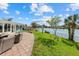 This beautiful backyard boasts a waterfront view with a paver patio and furniture at 424 Shade Ter, Venice, FL 34293