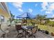 This backyard features a table with seating, a jacuzzi, a lush lawn, and a water view at 424 Shade Ter, Venice, FL 34293