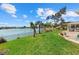 Picturesque backyard with a lush lawn, serene lake views, and patio area with comfortable seating at 424 Shade Ter, Venice, FL 34293