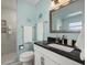 Bright bathroom with a walk-in shower, large mirror, vanity, and coastal-themed decor at 424 Shade Ter, Venice, FL 34293