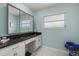 Light and airy bathroom with a black granite countertop and a large vanity with cabinets at 424 Shade Ter, Venice, FL 34293