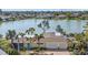 Waterfront home featuring a charming light yellow exterior, attached two car garage, and lush landscaping at 424 Shade Ter, Venice, FL 34293
