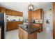 The kitchen has an island, wood cabinets and granite countertops at 424 Shade Ter, Venice, FL 34293