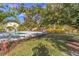 Beautiful backyard featuring a modern pool, grey brick pavers, lush plants, and trees with bright pink blooms at 432 Palmetto Ct, Venice, FL 34285