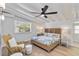 Bright bedroom featuring a ceiling fan, wood floors, and a wicker chair near the window at 432 Palmetto Ct, Venice, FL 34285