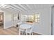 Breakfast nook with white table and chairs set by a large sunny window and door to the outside at 432 Palmetto Ct, Venice, FL 34285